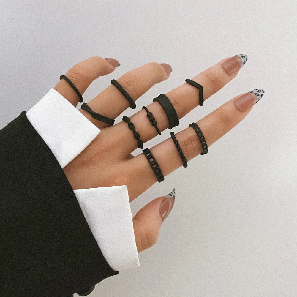 Black knuckle chain ring set on fingers, linked band design