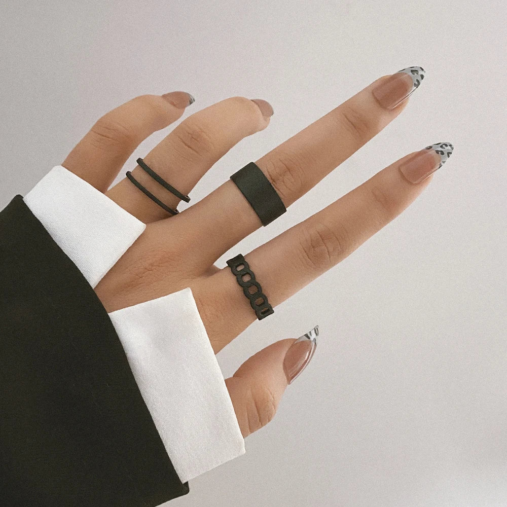 Black knuckle chain ring set on fingers, geometric link pattern