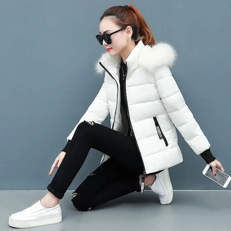 White hooded puffer parka with faux fur hood trim and front zipper, quilted puffy design