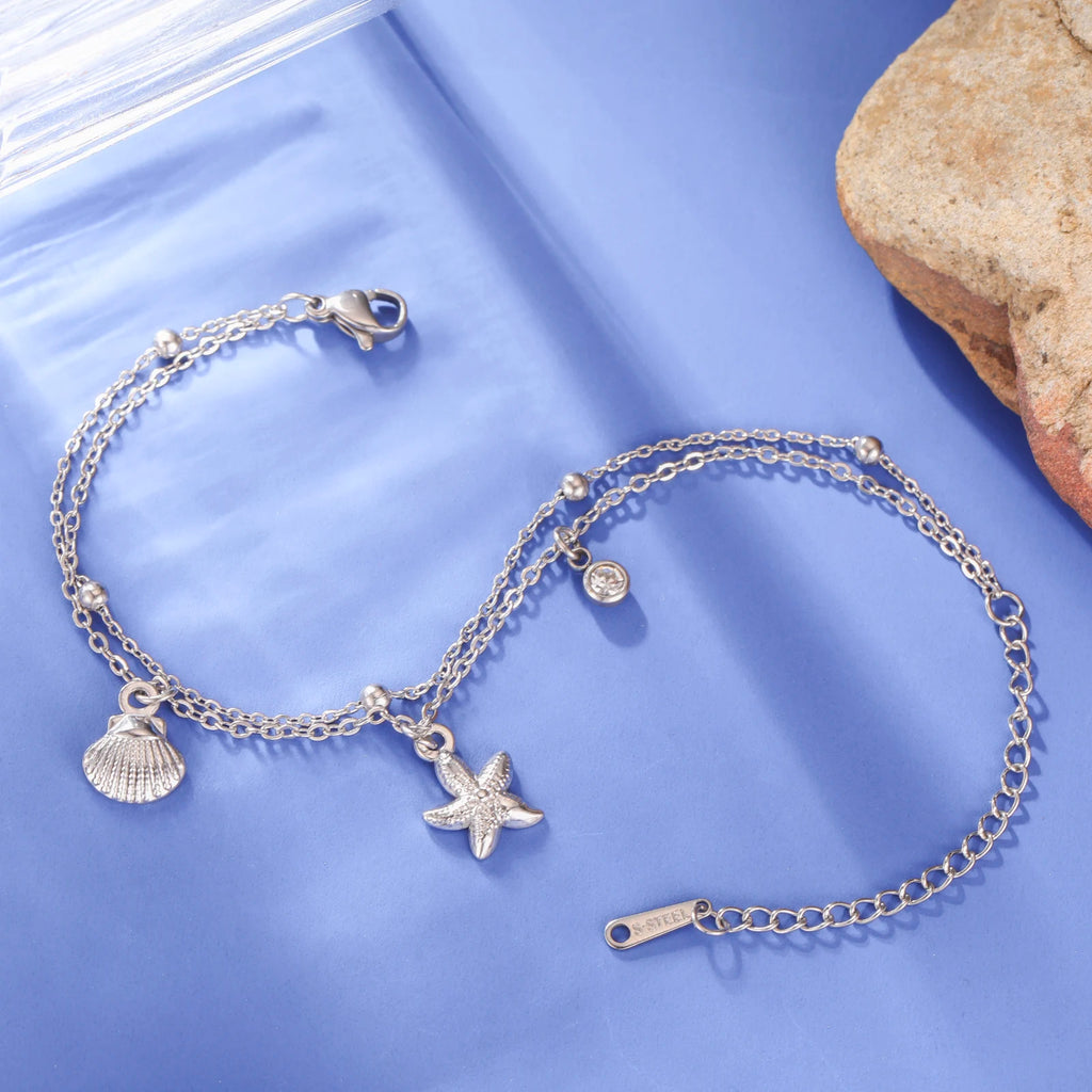 Silver-tone starfish and seashell charm bracelet with round gem and lobster clasp