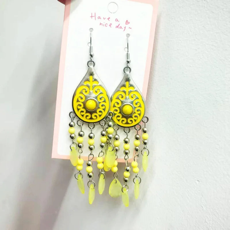 Yellow teardrop bead tassel dangle earrings with ornate center and silver hooks