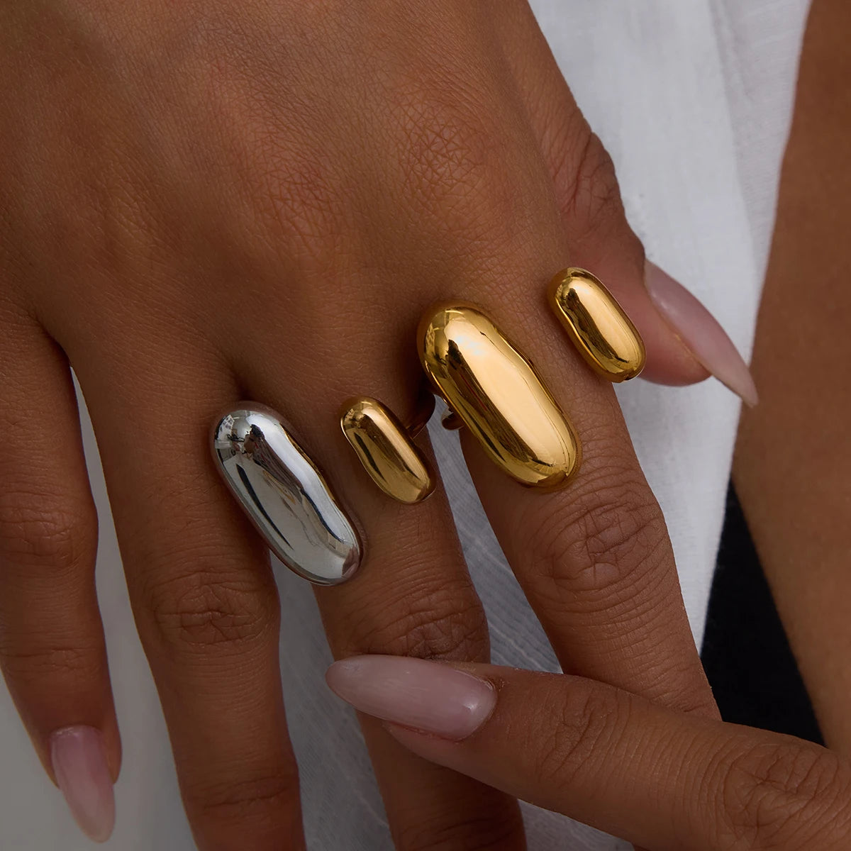 Geometric oval open ring in gold and silver tones, worn on hand