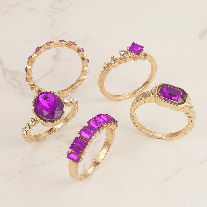 Gold-tone rings with purple square and oval crystals with faceted accents