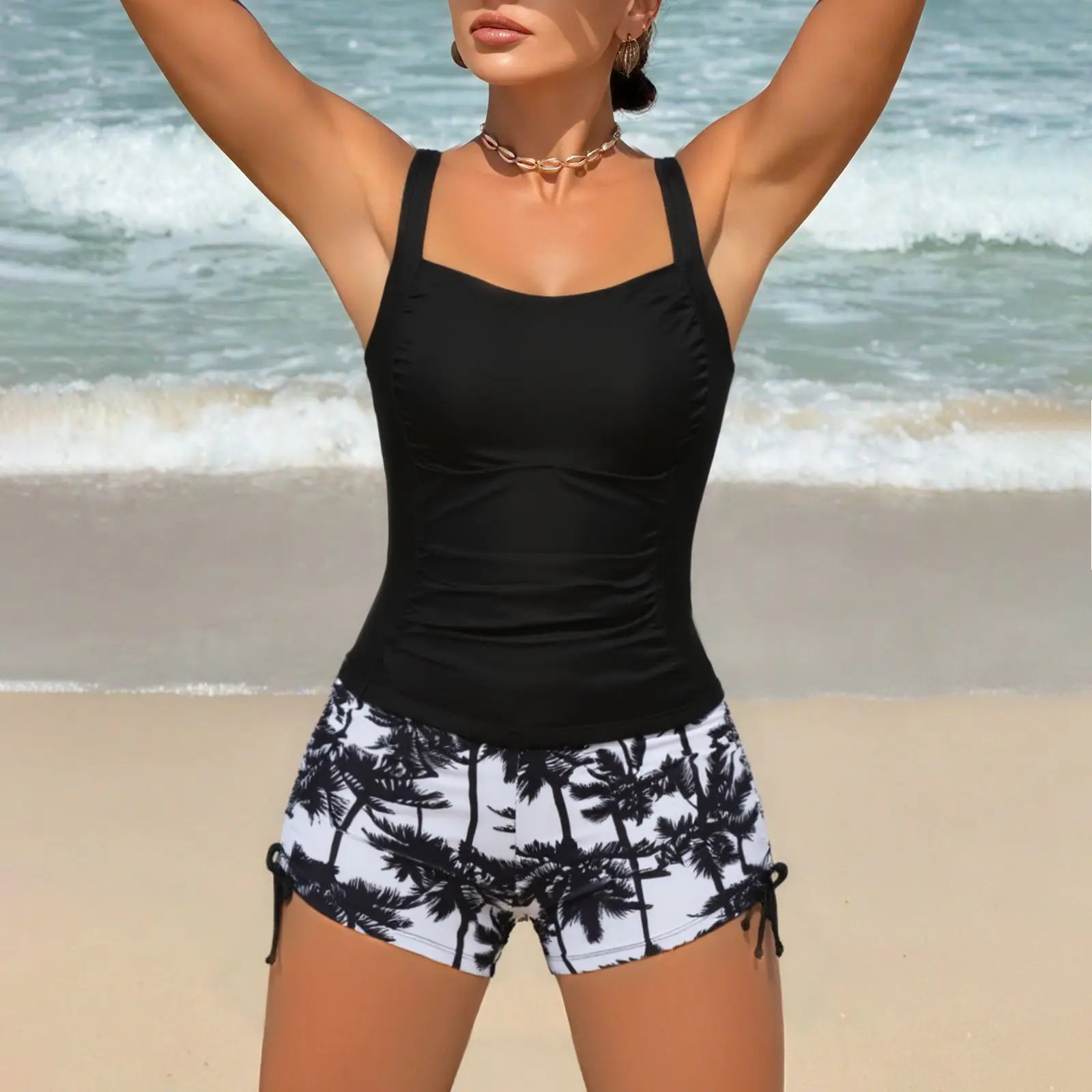Black strappy tankini top with palm-print shorts and ruched waist.