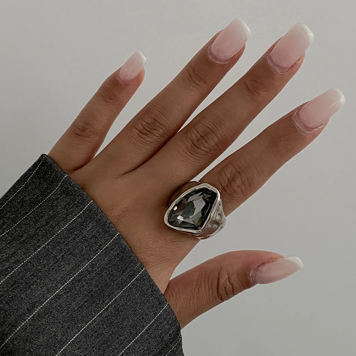 Silver oval open ring with dark faceted rhinestone on finger