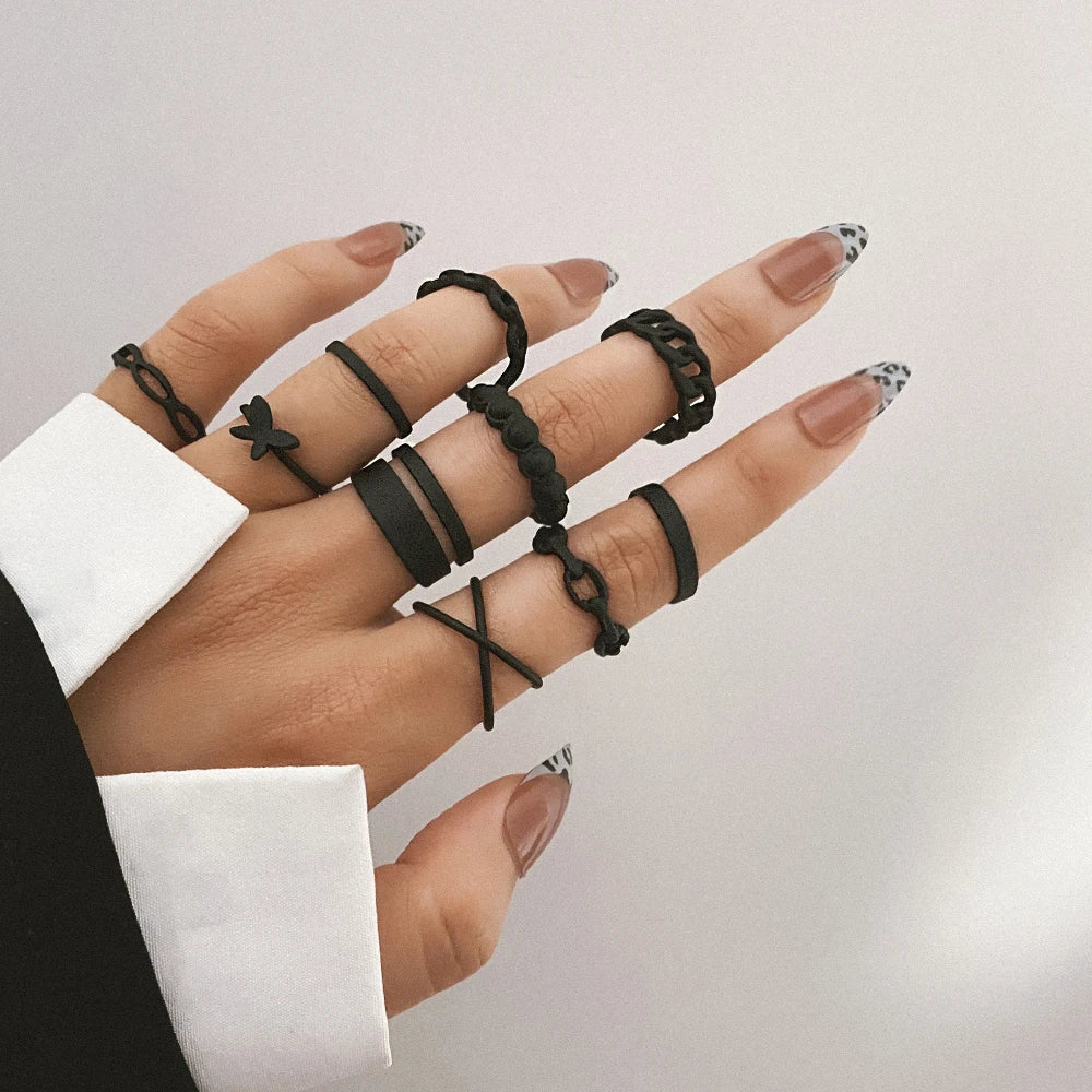 Black knuckle ring set with stacked bands, including star charm ring
