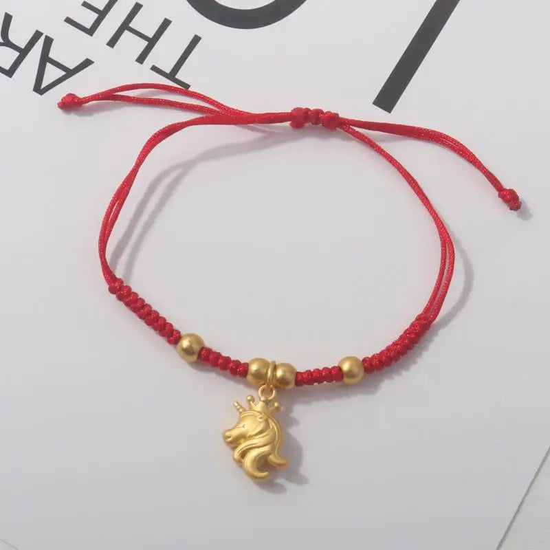 Red rope bracelet with gold beads and a gold horse charm