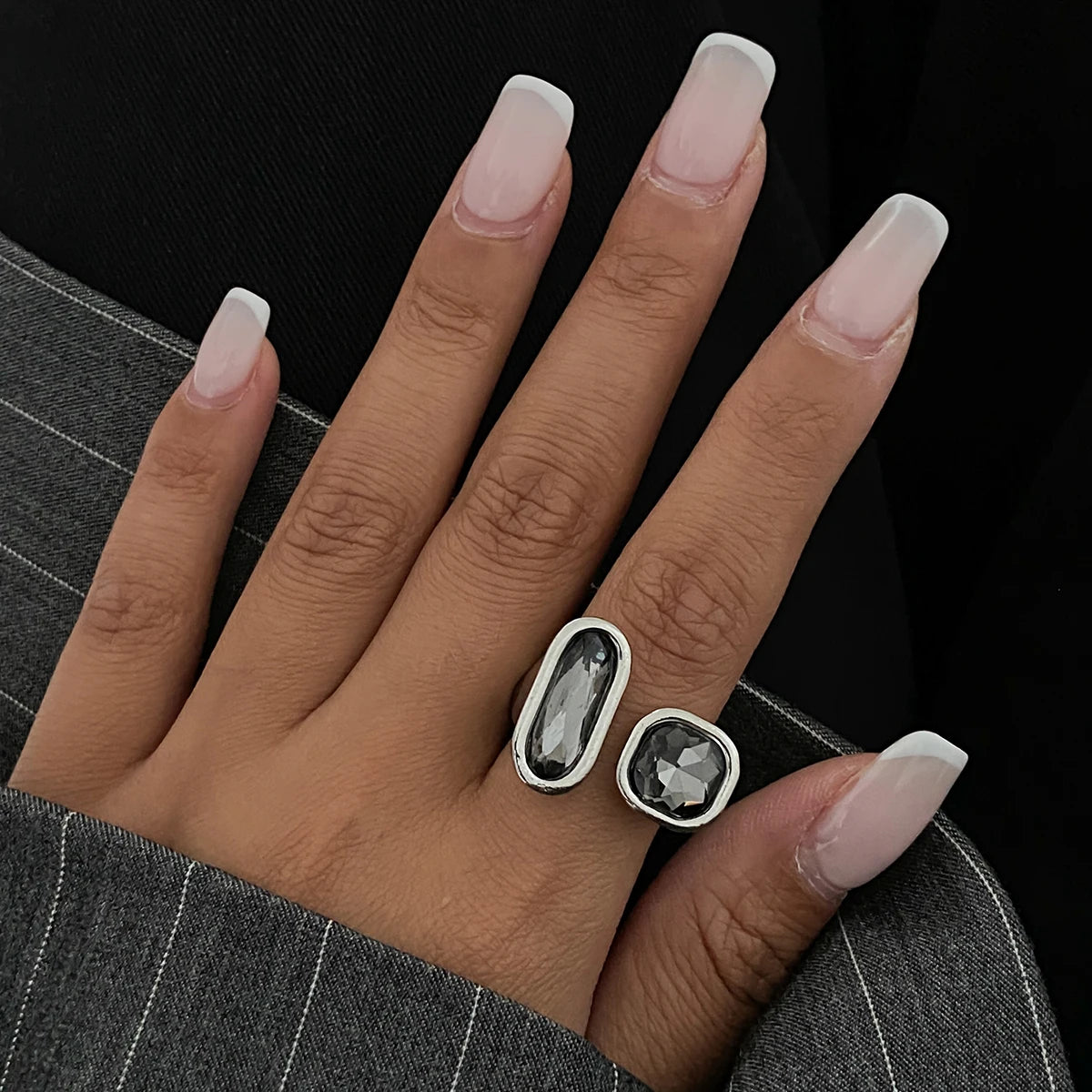 Silver open rings with oval and round dark faceted rhinestones on finger