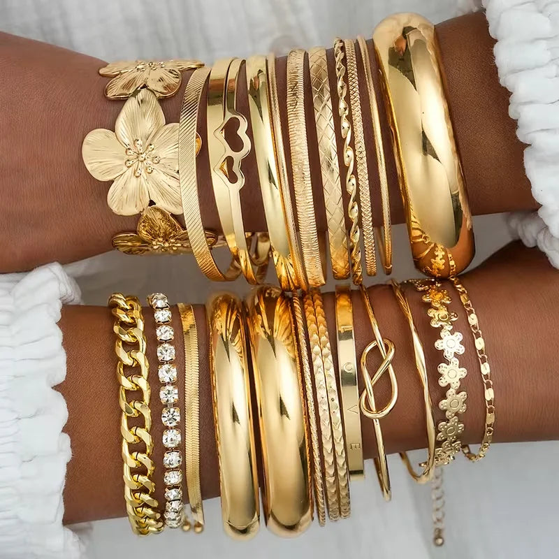 Gold-tone bracelet set with mixed bangles, chain links, and heart charm accents