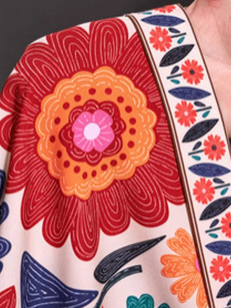 Red floral print fabric close-up with multicolor flowers and white trim