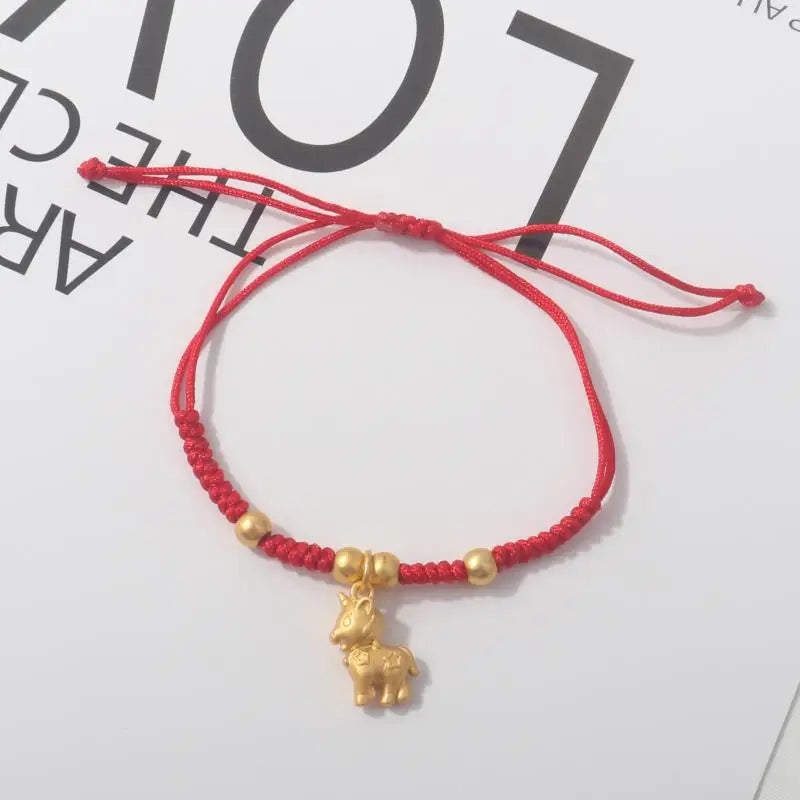 Red rope bracelet with gold beads and standing gold horse charm pendant.