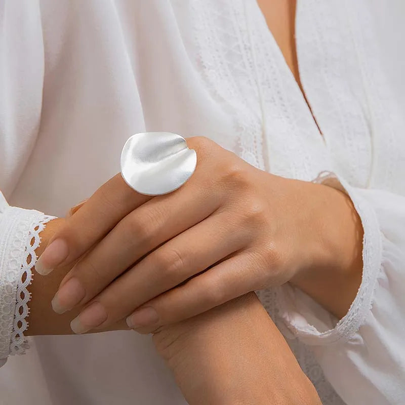 Silver-tone open adjustable ring with smooth oval cuff top on hand