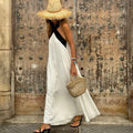 White halter neck linen maxi dress with cross-back straps, sleeveless, full skirt