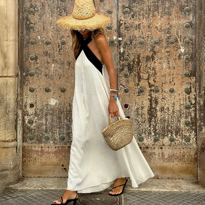 White halter neck linen maxi dress with cross-back straps, sleeveless, full skirt