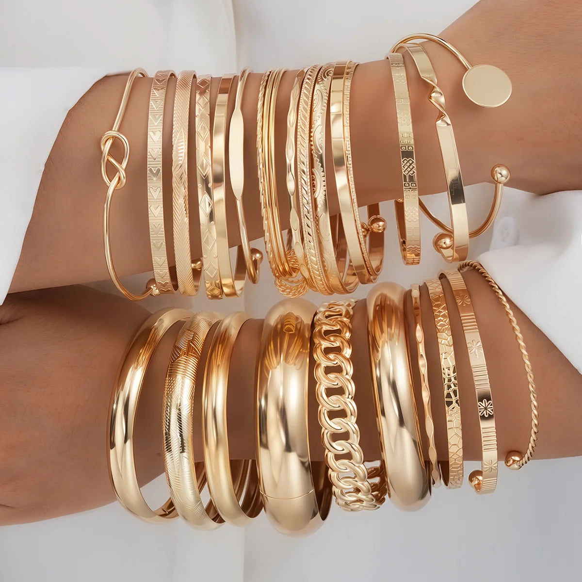 Gold-tone bracelet set with slim bangles, chain links, and heart charm detail