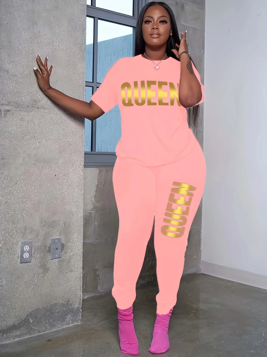 Light pink plus-size T-shirt and jogger set with yellow QUEEN print on chest and leg.