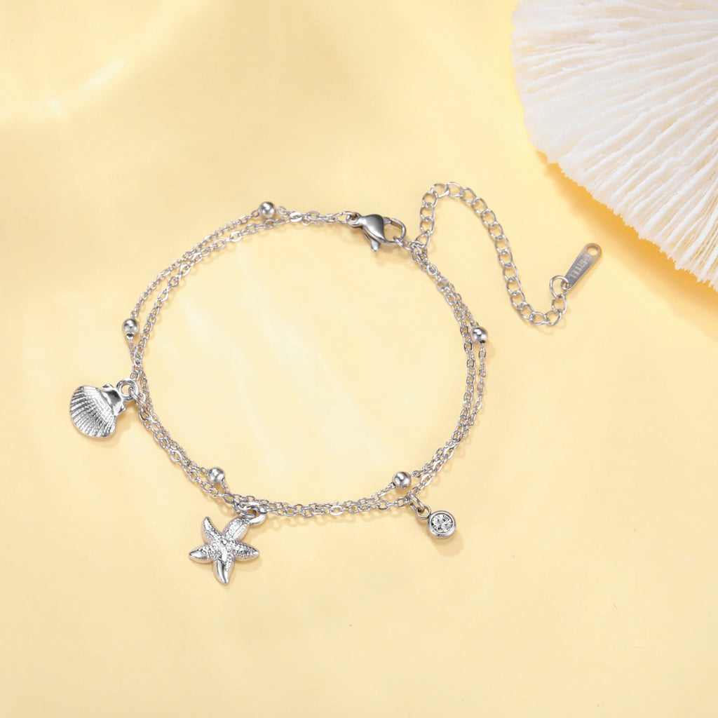 Silver-tone starfish and seashell charm bracelet with round gem and lobster clasp