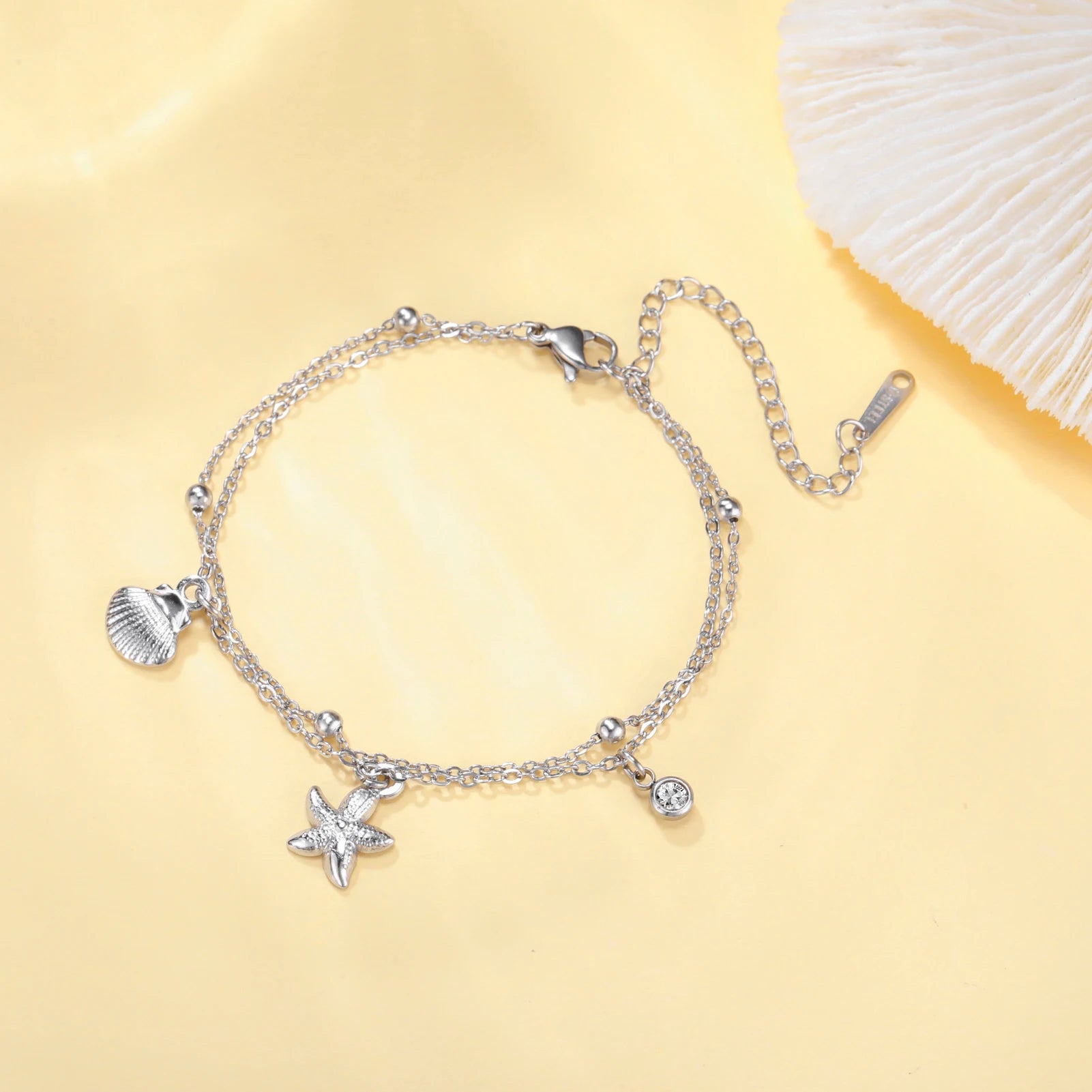 Silver-tone starfish and seashell charm bracelet with round gem and lobster clasp
