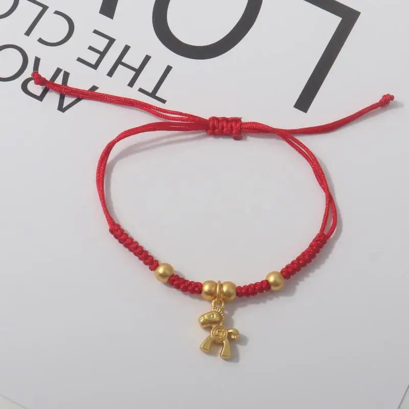 Red cord bracelet with gold beads and gold horse charm with red accent.