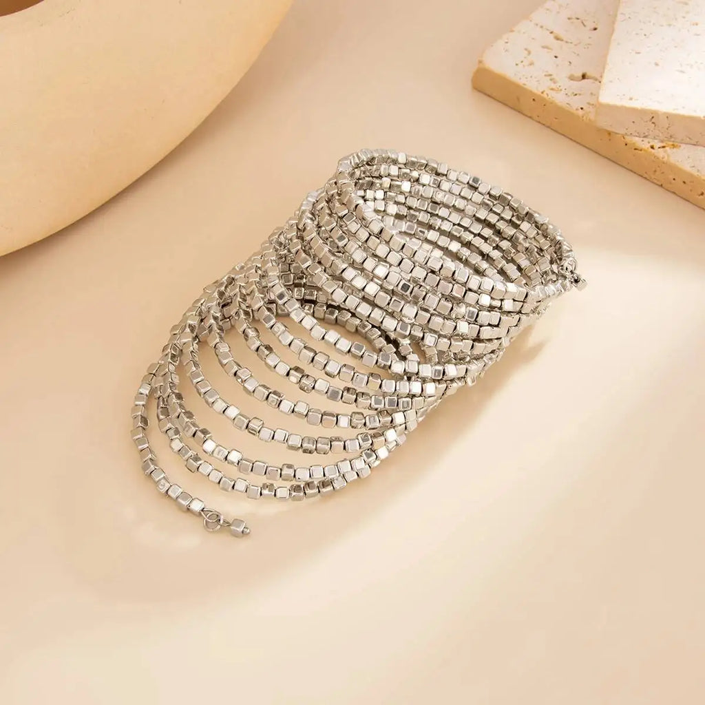 Silver-tone wide beaded cuff bracelet with multiple rows of square beads.