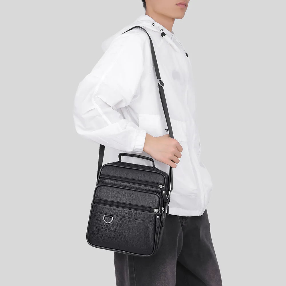 Black leather crossbody bag worn crossbody, front zip compartments, adjustable strap