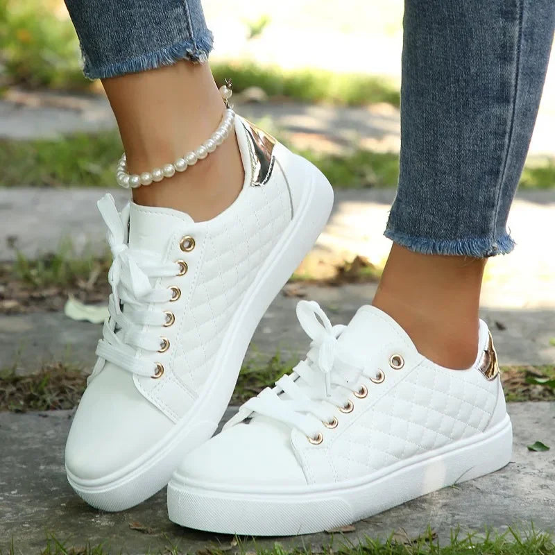 White lace-up platform sneakers with quilted texture, gold eyelets, and white rubber sole