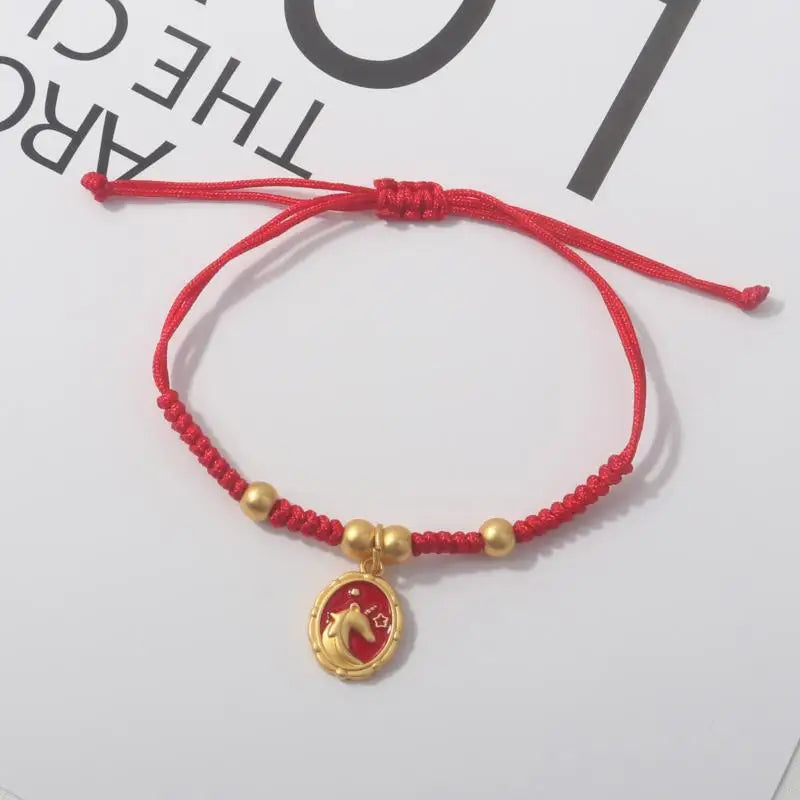 Red rope bracelet with gold beads and a round gold horse pendant