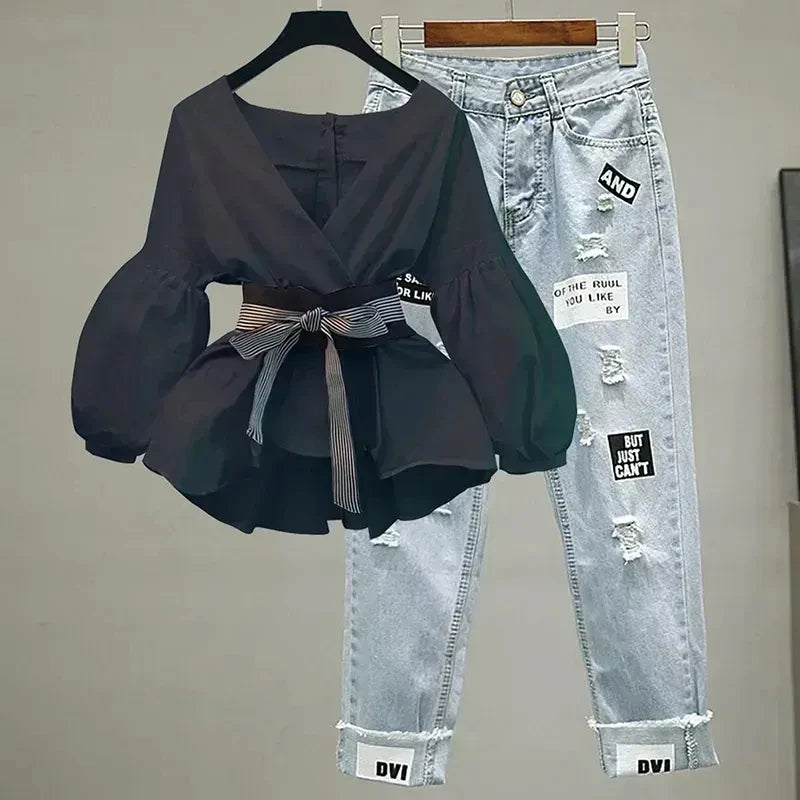 Black top paired with light-wash ripped jeans on hangers