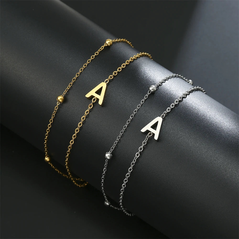Initial letter bracelet set with A and A charms; gold and silver-tone chains