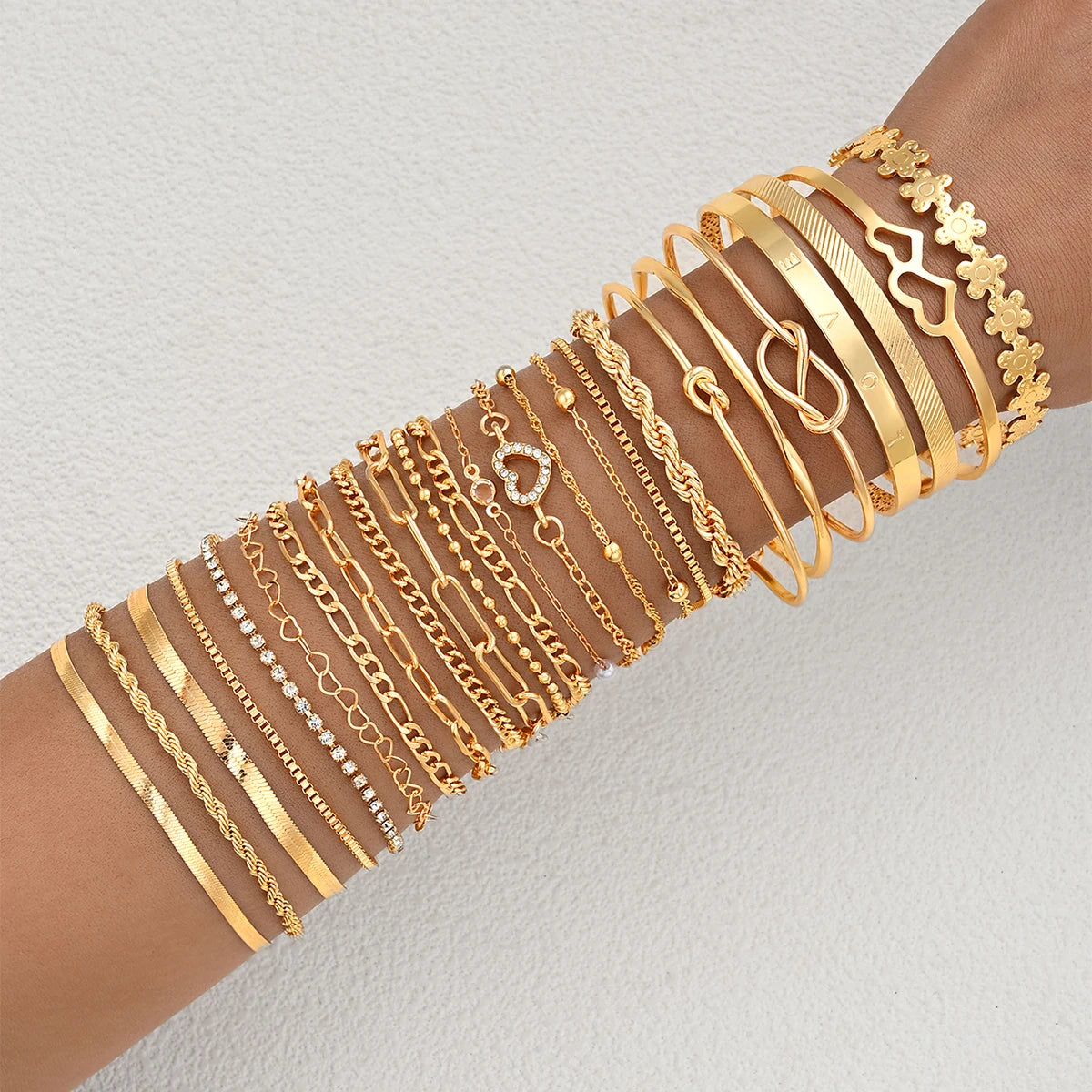Gold-tone charm bracelet set with heart and flower-style link accents