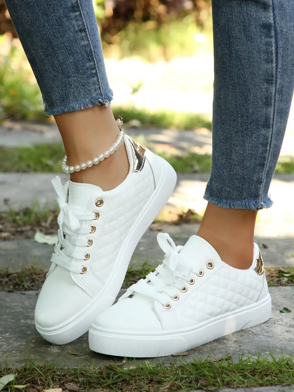 White quilted lace-up platform sneakers with gold eyelets, side view.