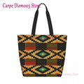 Canvas tote bag with black background and gold, green, red geometric square pattern and black handles