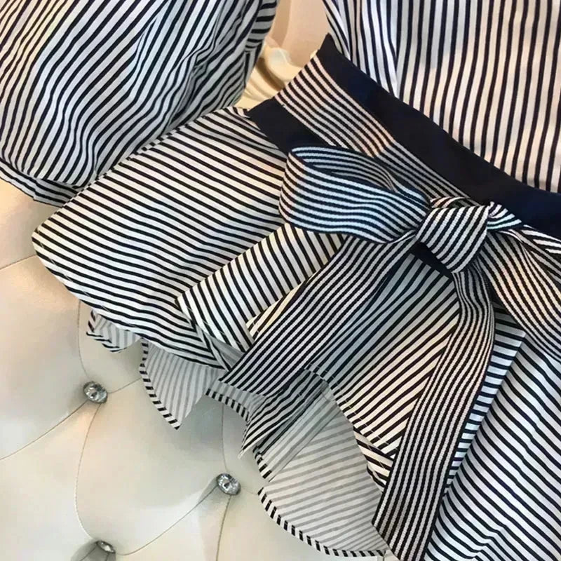 Striped peplum-style chiffon top with V-neck, cuffed sleeves, and navy button detail