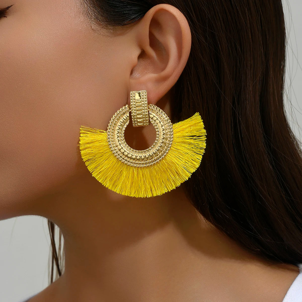 Gold-tone fan stud earrings with round crystal hoop and yellow tassel fringes