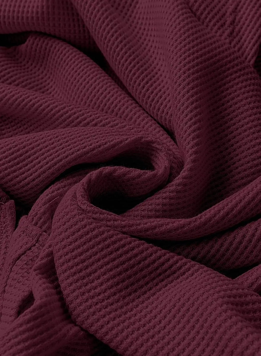Close-up of maroon waffle knit fabric texture on a hooded sweatshirt
