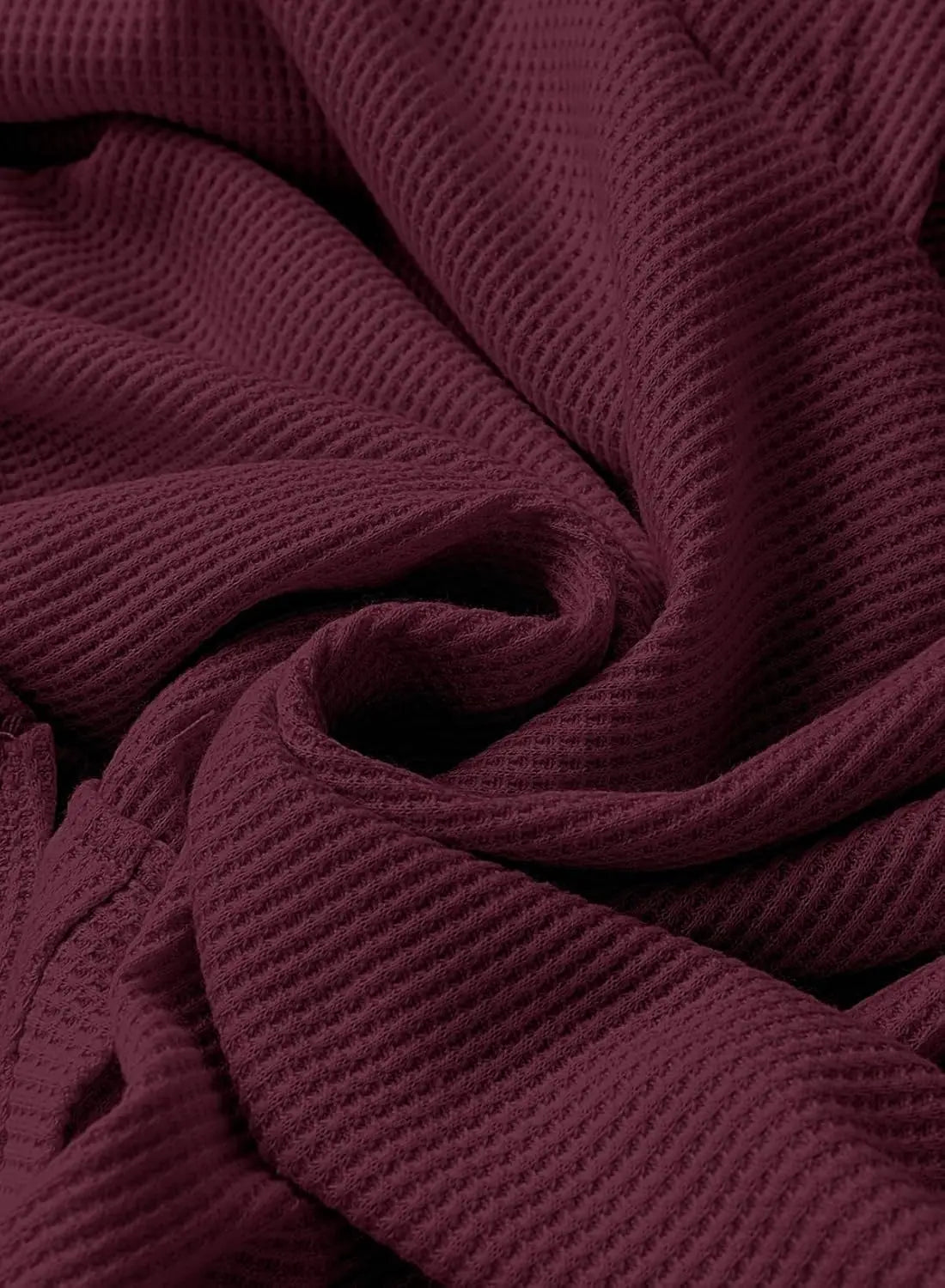 Close-up of maroon waffle knit fabric texture on a hooded sweatshirt