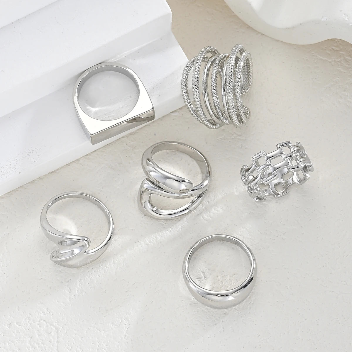 Silver-tone knuckle ring set with dome top ring, stacked bands, and square charm