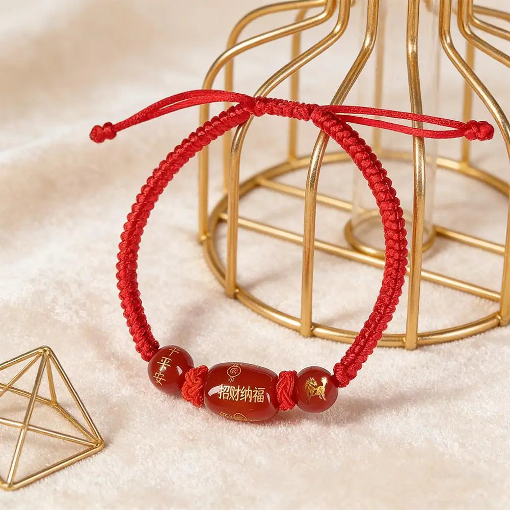Red string bracelet with oval brown bead and small horse charm bead accents