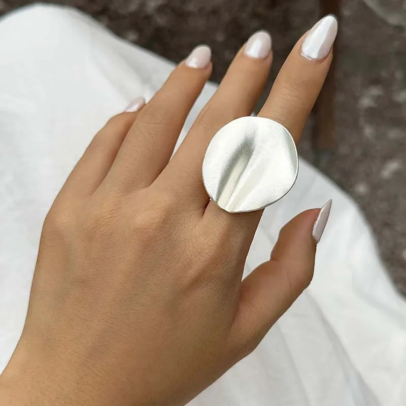 Silver-tone open adjustable ring with irregular oval cuff top on hand