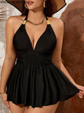 Black halter tankini swim dress with gold-accent straps, smocked waist, tiered skirt hem