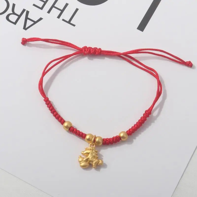 Red rope bracelet with gold beads and gold horse charm pendant.