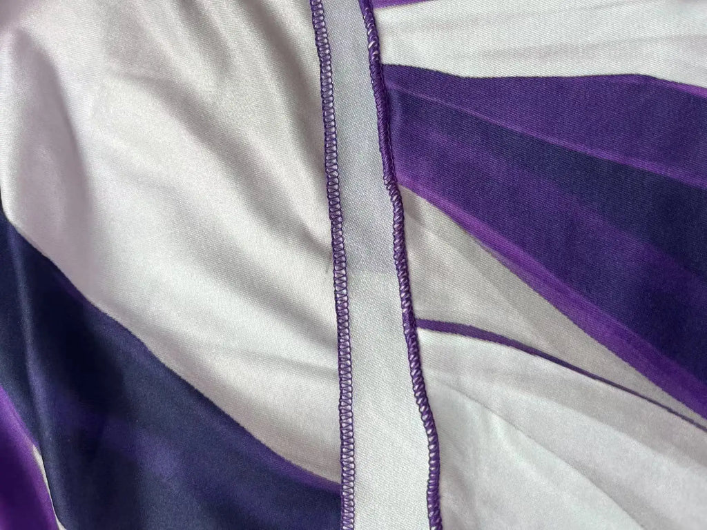 Asymmetrical geometric stripe dress detail with double-strap neckline and purple trim stitching