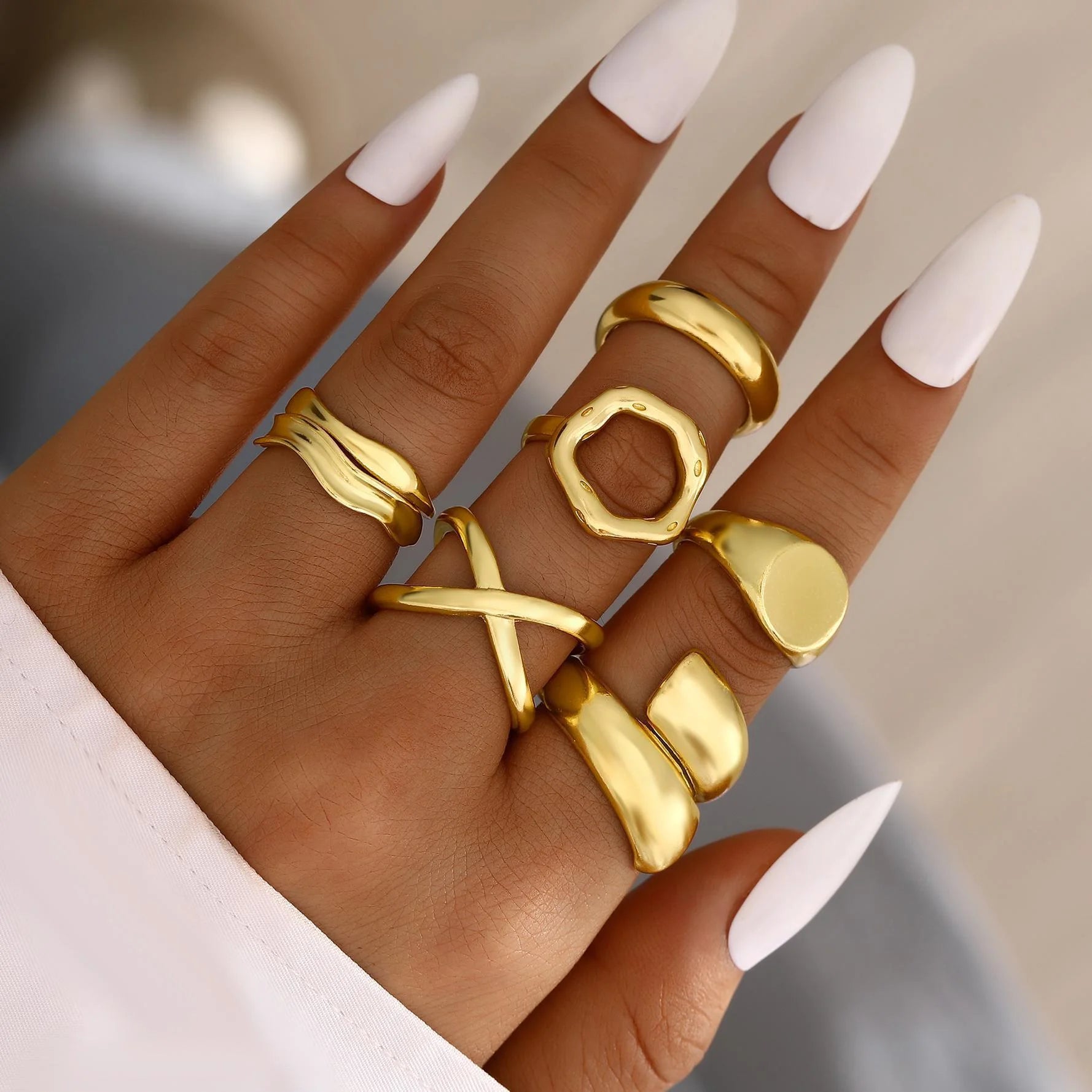 Gold-tone knuckle ring set with stacked bands and chunky openwork rings