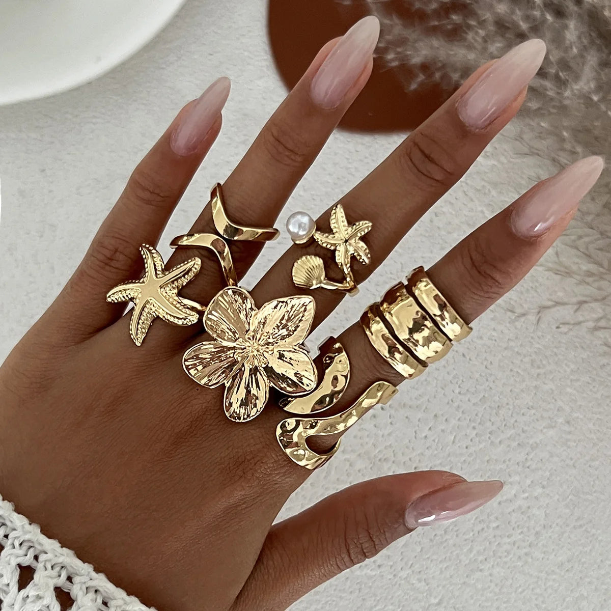 Gold-tone knuckle rings with starfish charms and large flower motifs