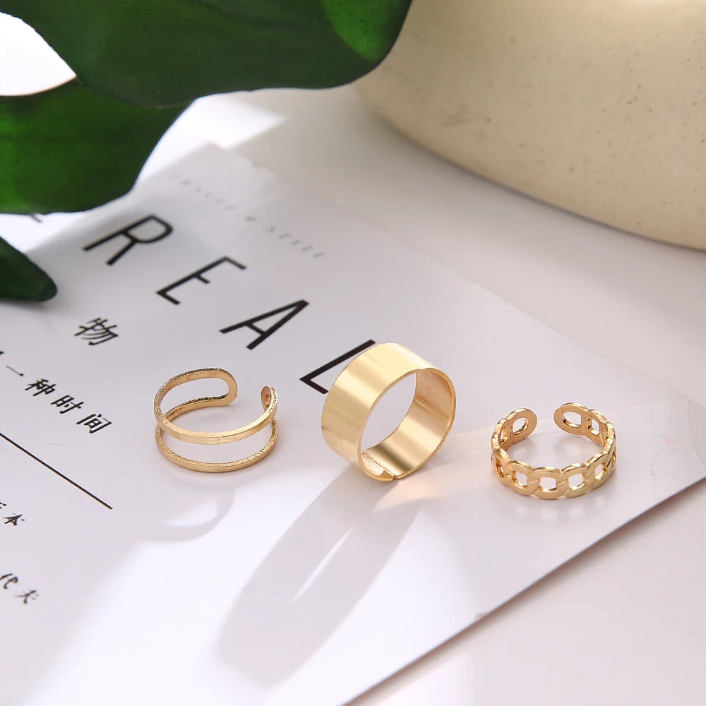 Gold tone chain knuckle rings set on display card