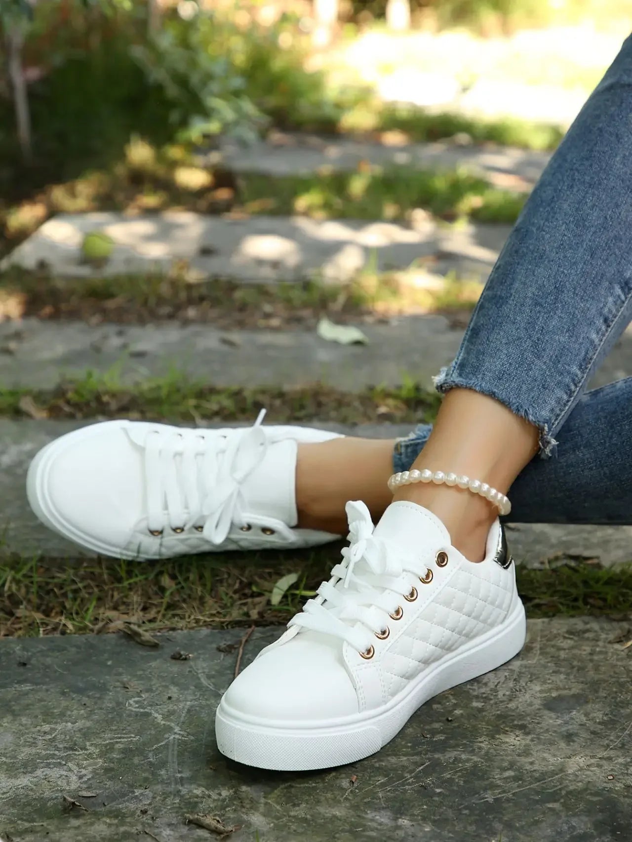 White quilted lace-up platform sneakers with gold eyelets, toe and top view.