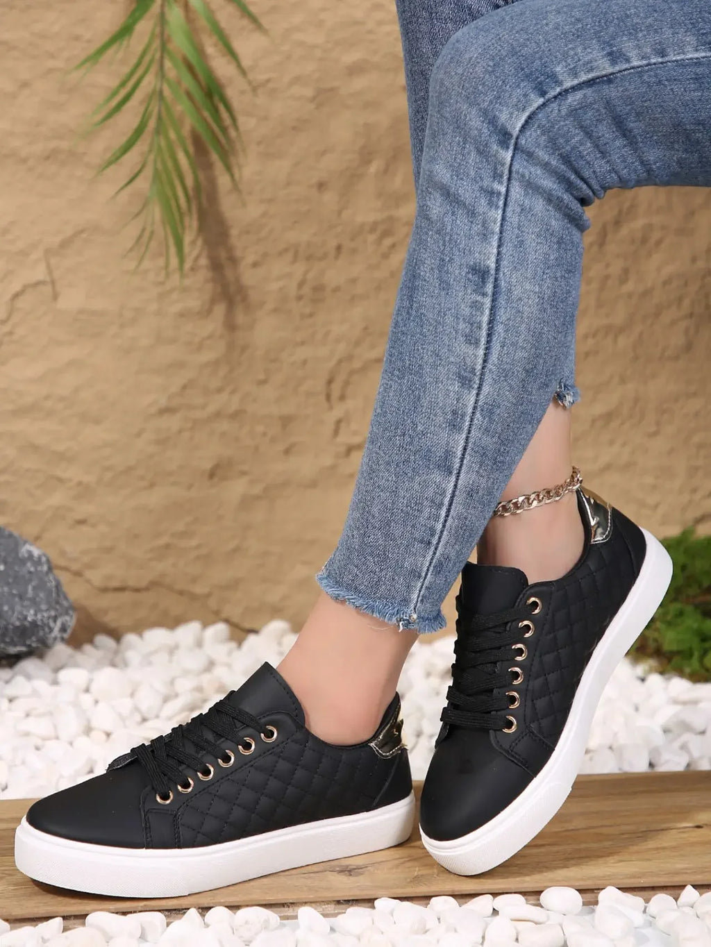 Black quilted lace-up platform sneakers with gold eyelets and white rubber sole
