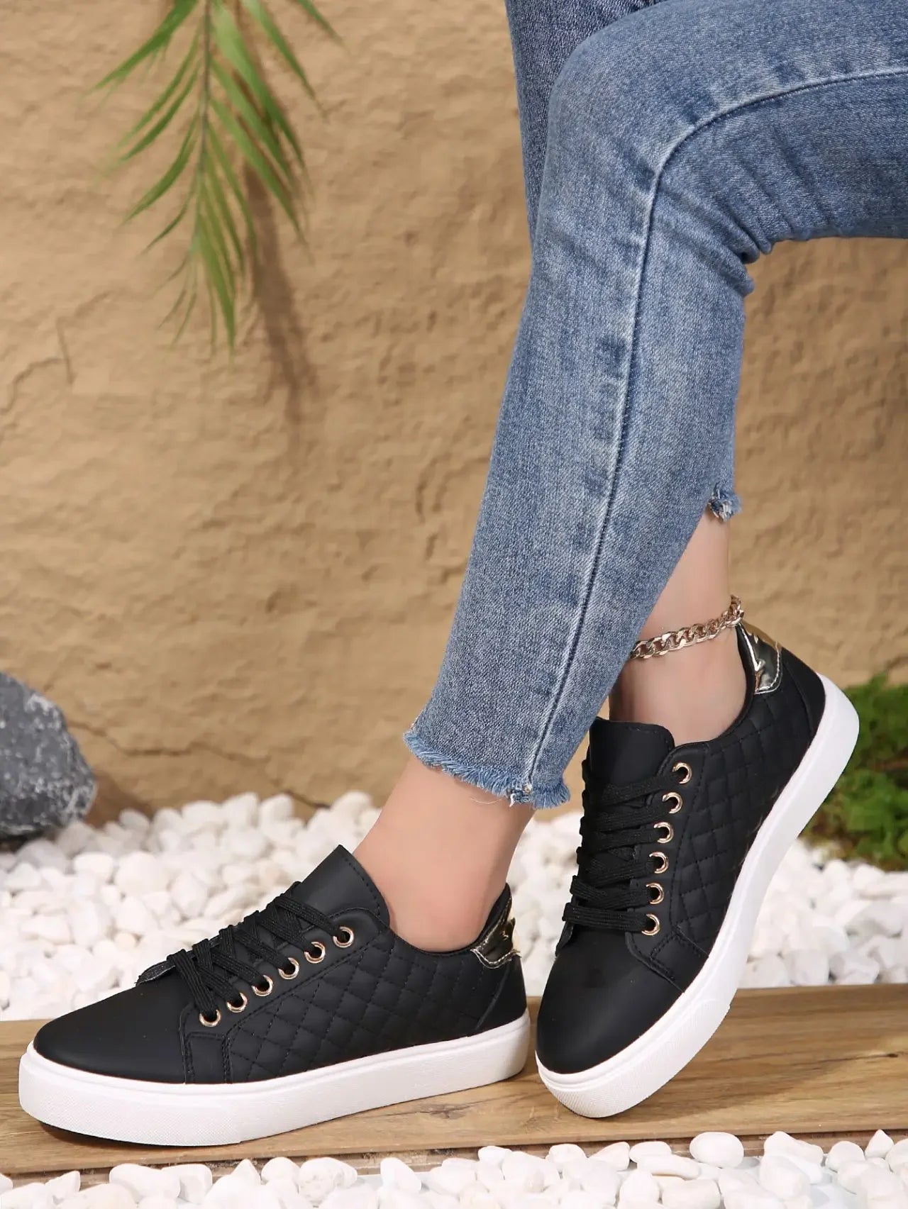 Black quilted lace-up platform sneakers with gold eyelets and white rubber sole