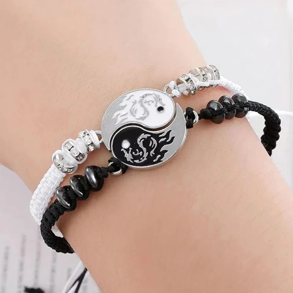 Two cord bracelets on wrist featuring yin-yang dragon moon pendants and bead details