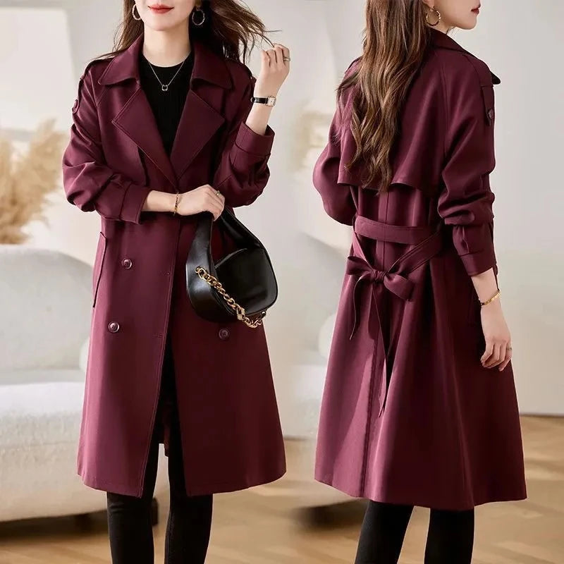 Women’s burgundy trench coat with tie belt at waist and double-breasted button closure